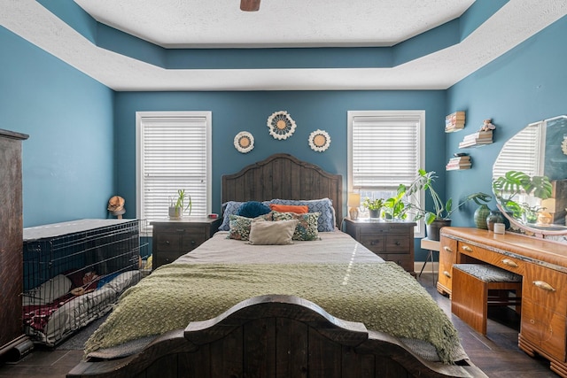 bedroom with multiple windows, ceiling fan, and a textured ceiling