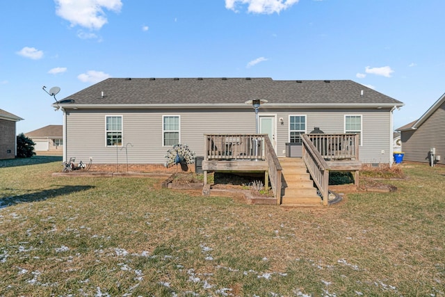 rear view of house featuring a deck and a lawn