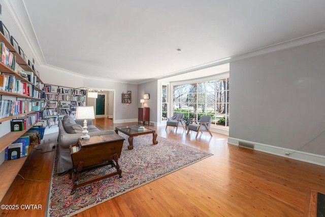 living room with wood-type flooring and ornamental molding