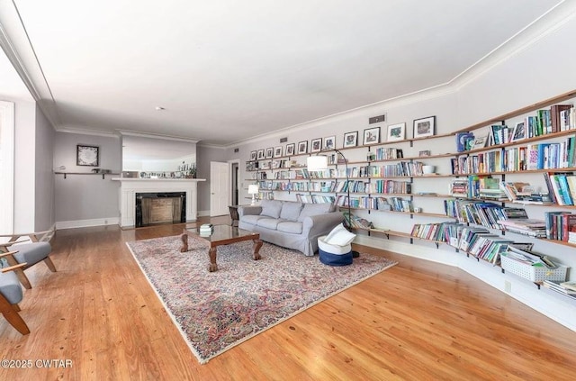 living room with crown molding and wood-type flooring