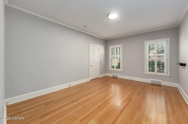 spare room featuring ornamental molding and light hardwood / wood-style flooring