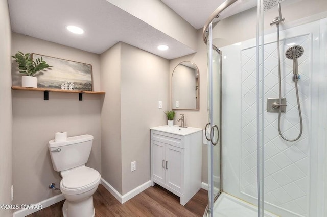 bathroom with vanity, wood-type flooring, toilet, and walk in shower