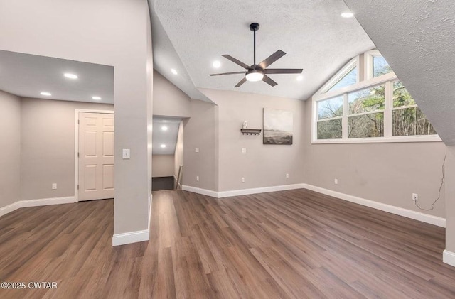 unfurnished living room featuring lofted ceiling, ceiling fan, dark hardwood / wood-style flooring, and a textured ceiling