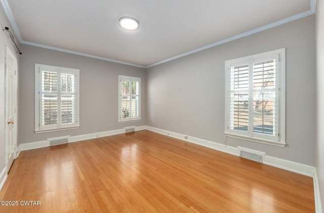 unfurnished room with crown molding, a wealth of natural light, and light hardwood / wood-style floors