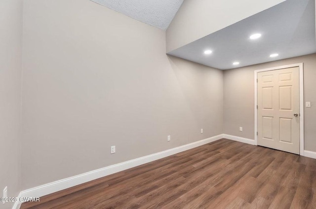 empty room with dark hardwood / wood-style floors and a textured ceiling