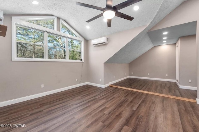 additional living space featuring lofted ceiling, a textured ceiling, an AC wall unit, dark hardwood / wood-style floors, and ceiling fan