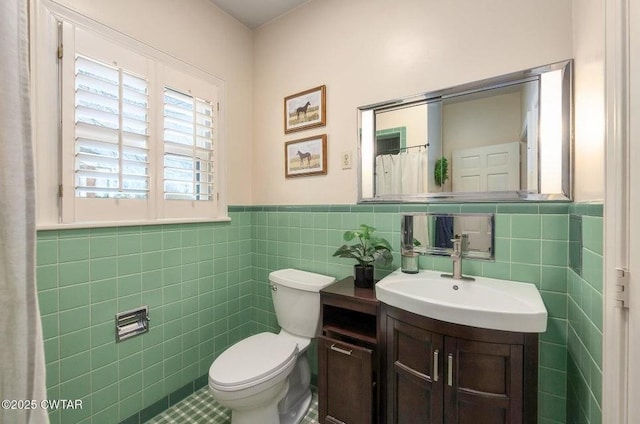 bathroom featuring tile walls, vanity, and toilet