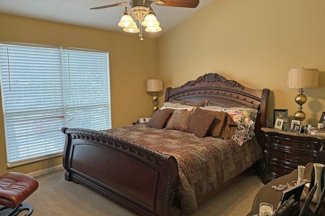 carpeted bedroom with ceiling fan, vaulted ceiling, and multiple windows