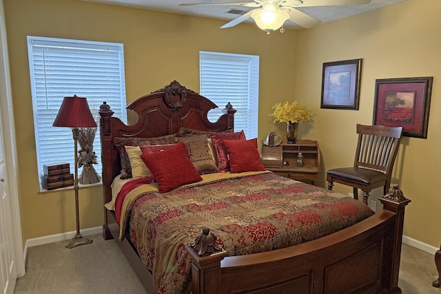 carpeted bedroom with ceiling fan and multiple windows