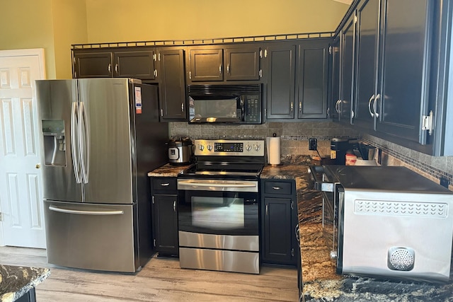 kitchen with appliances with stainless steel finishes, light wood-type flooring, dark stone counters, and decorative backsplash