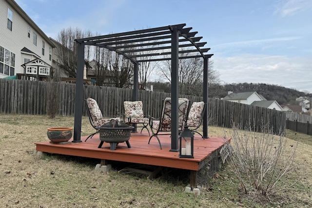 wooden terrace featuring a yard, a pergola, and a fire pit