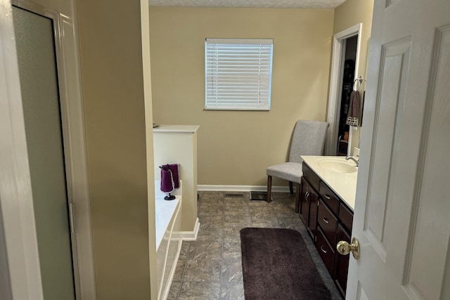 bathroom with vanity, separate shower and tub, and a textured ceiling