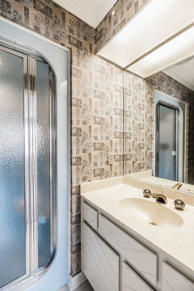 bathroom featuring walk in shower, ornamental molding, and vanity