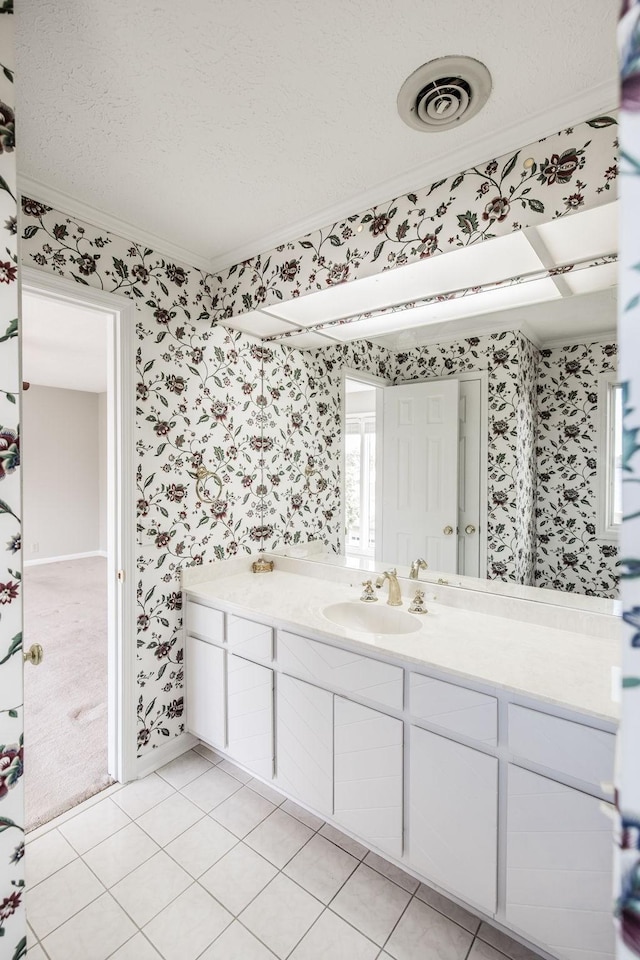 bathroom with vanity, tile patterned floors, ornamental molding, and a textured ceiling