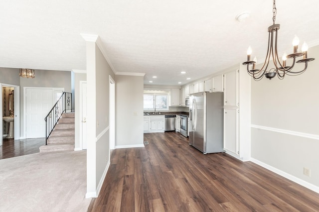 kitchen with hanging light fixtures, white cabinetry, appliances with stainless steel finishes, and a chandelier