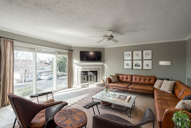 living room with a tile fireplace, crown molding, carpet, and a textured ceiling