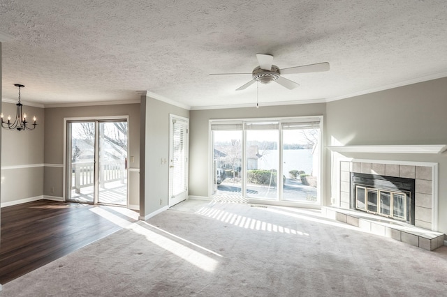 unfurnished living room featuring a tile fireplace, carpet, a wealth of natural light, and crown molding