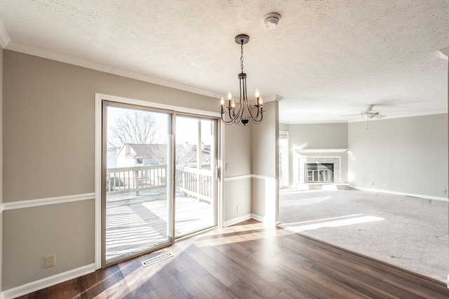 unfurnished dining area with crown molding, hardwood / wood-style floors, a textured ceiling, and a fireplace