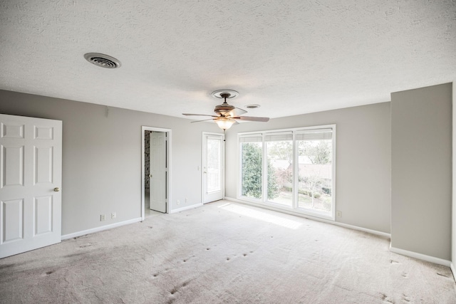 interior space with ceiling fan, light colored carpet, and a textured ceiling