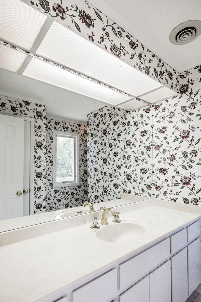 bathroom with ornamental molding and vanity