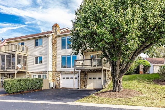 view of property featuring a garage and central AC unit