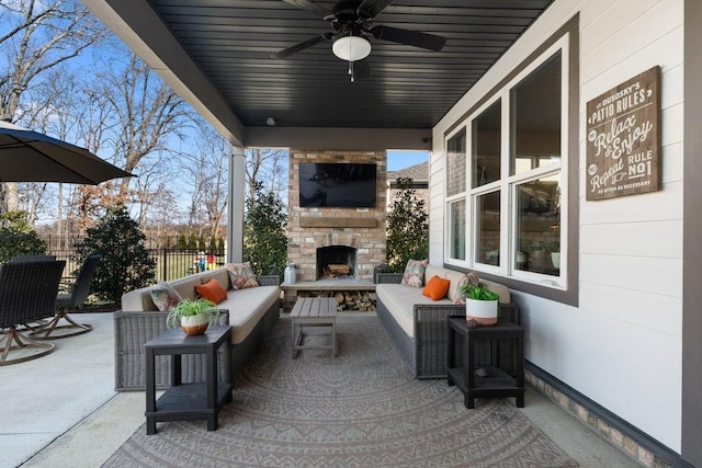 view of patio with an outdoor living space with a fireplace and ceiling fan