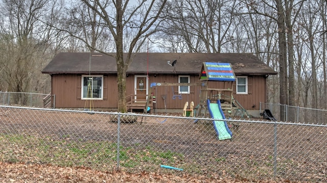 rear view of property featuring a playground