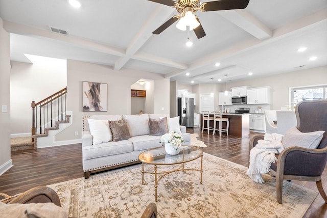 living room featuring beamed ceiling, ceiling fan, and dark wood-type flooring