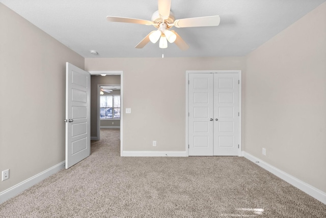 unfurnished bedroom featuring ceiling fan, a closet, and light carpet