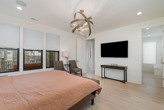 bedroom featuring an inviting chandelier and light hardwood / wood-style floors