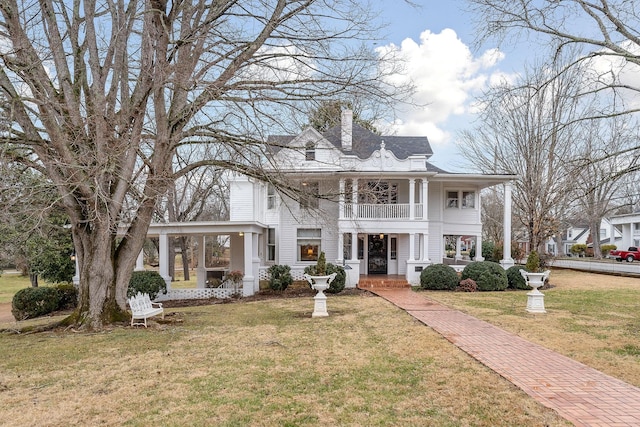 neoclassical home with a balcony and a front yard