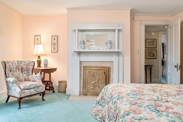 bedroom featuring a tiled fireplace, crown molding, and light colored carpet