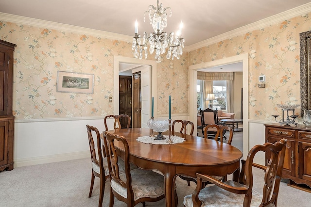 dining room with light carpet, ornamental molding, and an inviting chandelier