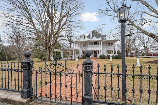 view of front of house featuring a front yard and a balcony