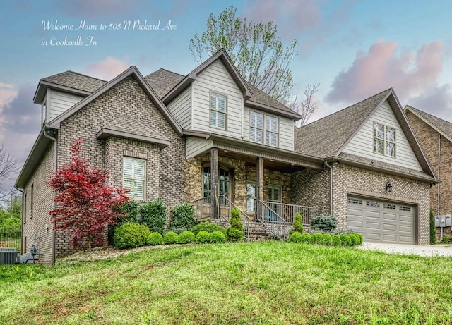 front of property with a garage, a front lawn, and covered porch