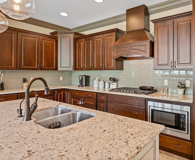 kitchen with tasteful backsplash, appliances with stainless steel finishes, sink, and custom range hood