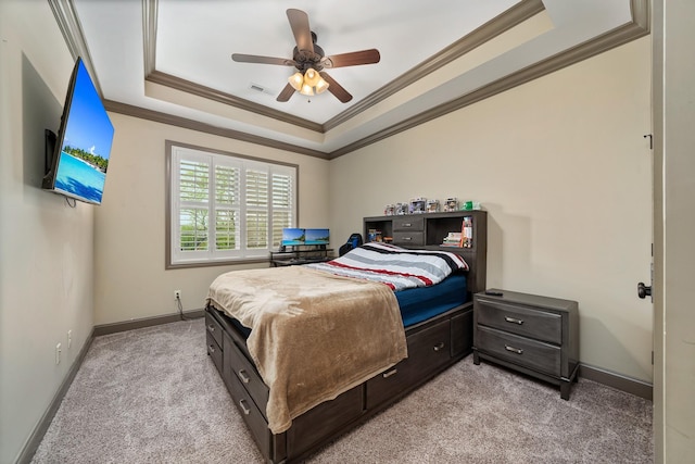 carpeted bedroom featuring crown molding, ceiling fan, and a raised ceiling