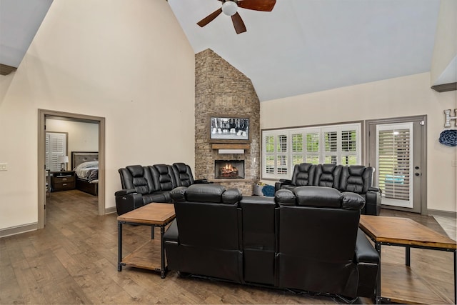 living room with ceiling fan, wood-type flooring, a fireplace, and high vaulted ceiling