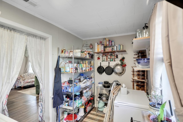 laundry room with hardwood / wood-style flooring, crown molding, and independent washer and dryer