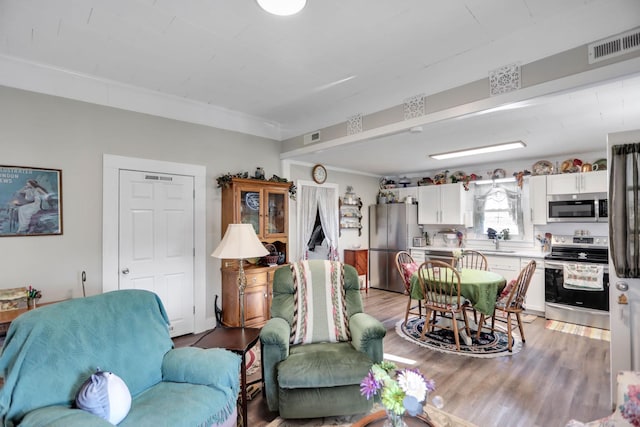 living room featuring sink and light hardwood / wood-style flooring