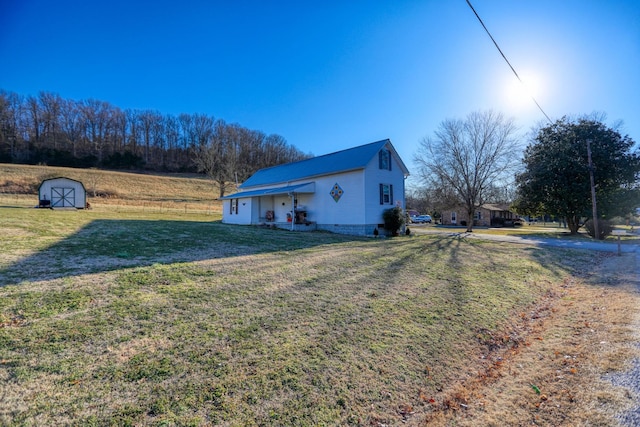 view of side of property featuring a storage shed and a yard