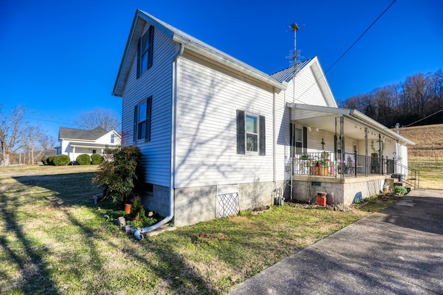 view of property exterior with covered porch and a lawn