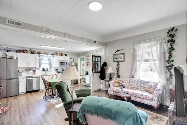 living room with a wealth of natural light and light hardwood / wood-style floors