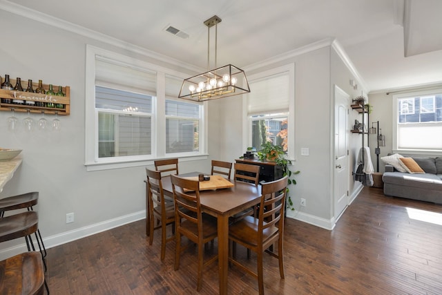 dining area with baseboards, visible vents, dark wood finished floors, crown molding, and a chandelier