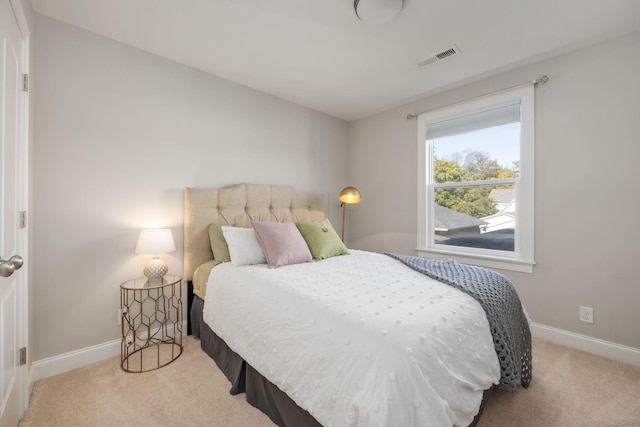 bedroom with light carpet, visible vents, and baseboards