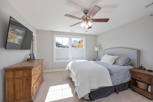 bedroom with baseboards, ceiling fan, visible vents, and light colored carpet