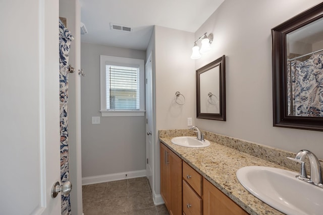 full bathroom featuring double vanity, a sink, visible vents, and baseboards