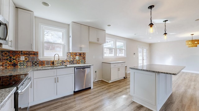 kitchen with a center island, appliances with stainless steel finishes, sink, and white cabinets