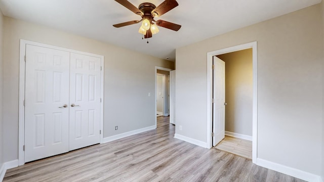 unfurnished bedroom featuring light hardwood / wood-style floors, a closet, and ceiling fan