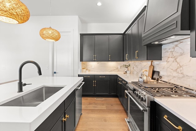 kitchen featuring sink, decorative light fixtures, light hardwood / wood-style flooring, custom range hood, and stainless steel appliances